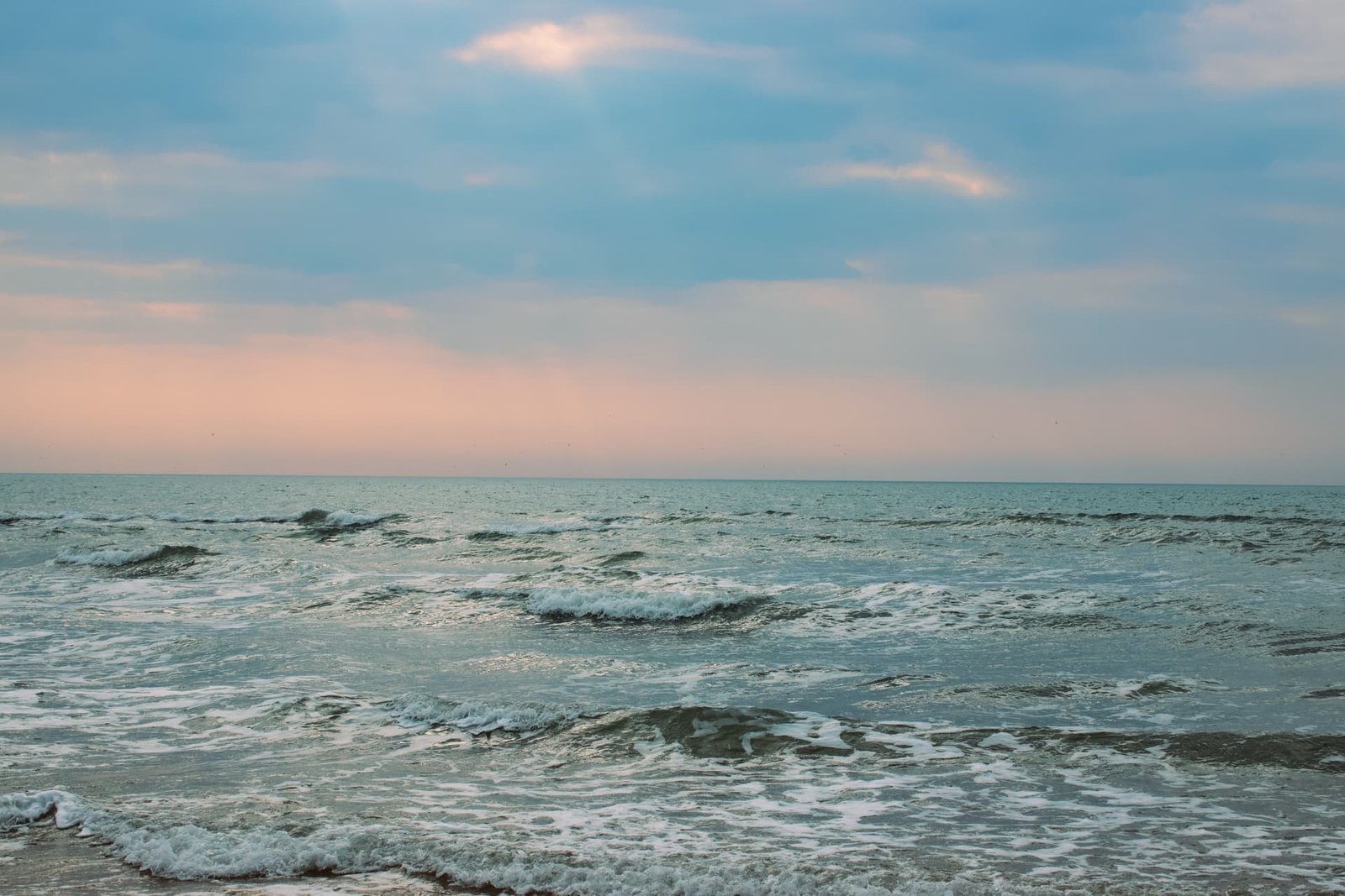 Vagues venant mourir sur le rivage sous un ciel de fin de journée, au niveau zéro.